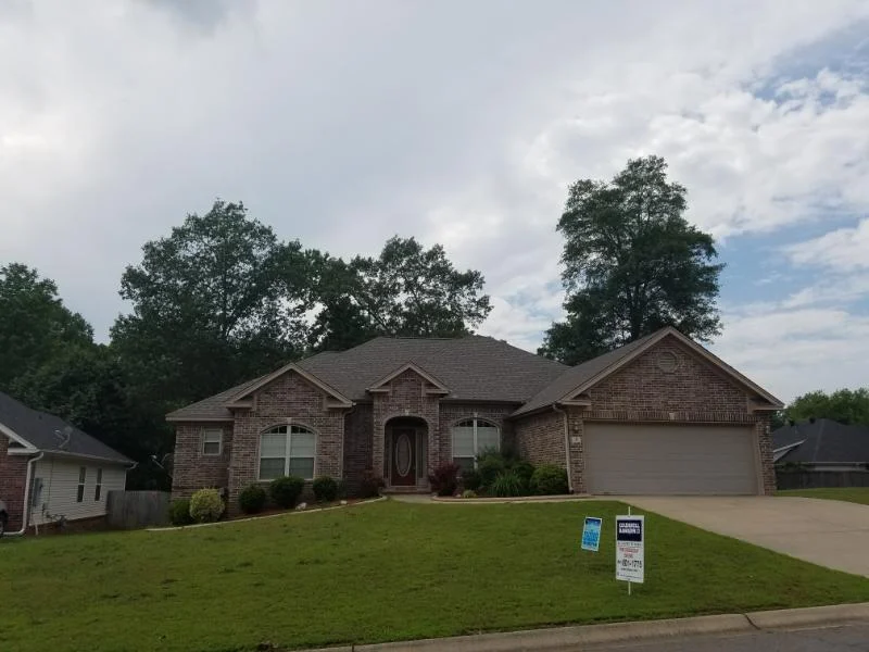 Brick-and-stone home with multiple gables and an attached garage from CAR’s residential portfolio