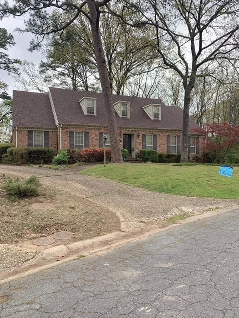 Two-story brick house with dormer windows and a shingle roof from CAR’s portfolio